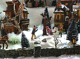 Further photograph of winter village, with houses, swing, snowman and figurines of children playing