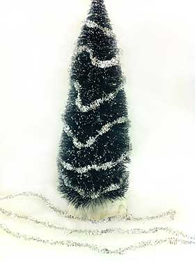 Image of miniature Christmas tree decorated with tiny strands of tinsel