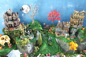 Picture of a spooky Halloween village with green mountains / hills